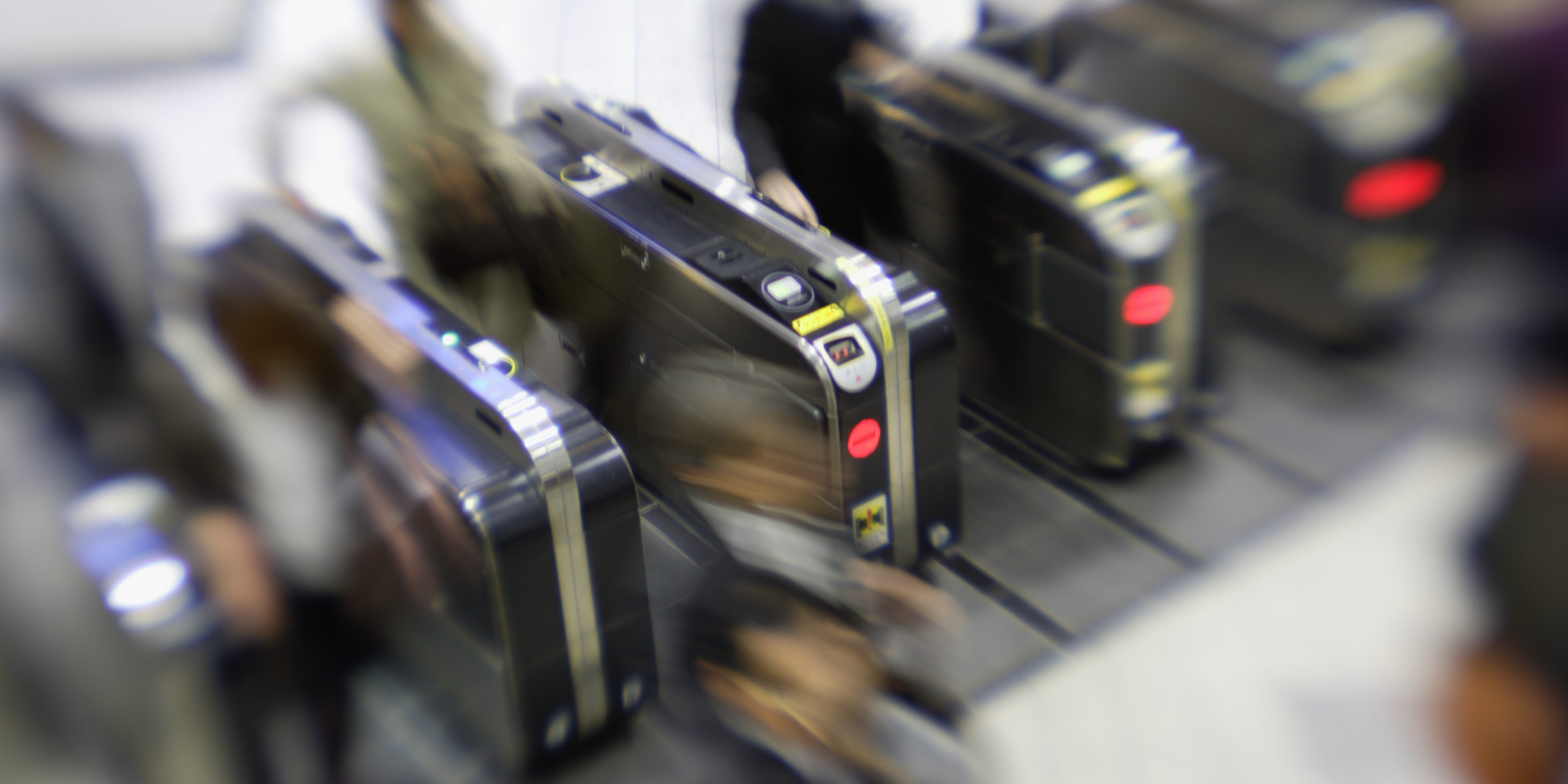 People passing through automatic ticket gate (blurred motion)